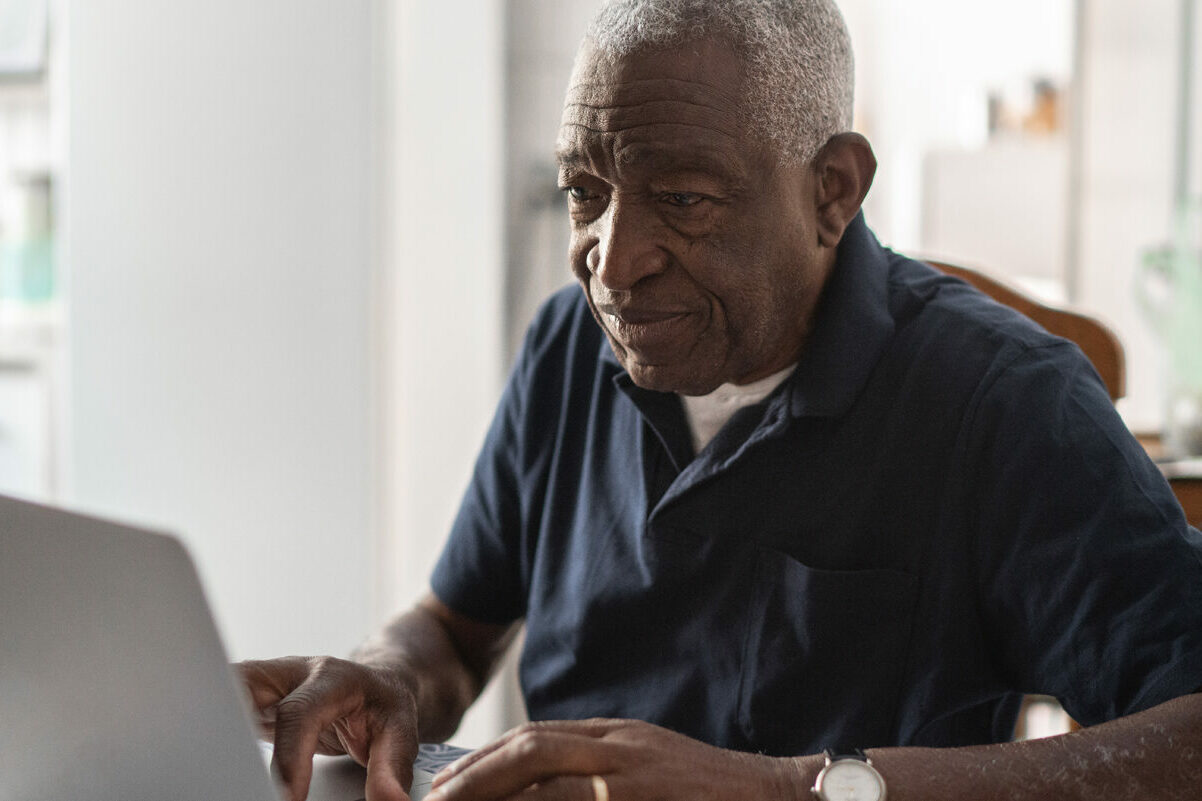 Older man working on a computer using Morphic's accessibility tool.